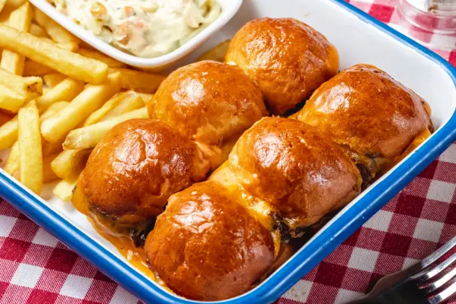 Golden Corral rolls with crispy fries and creamy coleslaw, served in a blue dish. Soft, golden buns filled with savory ingredients, perfect for a hearty meal.